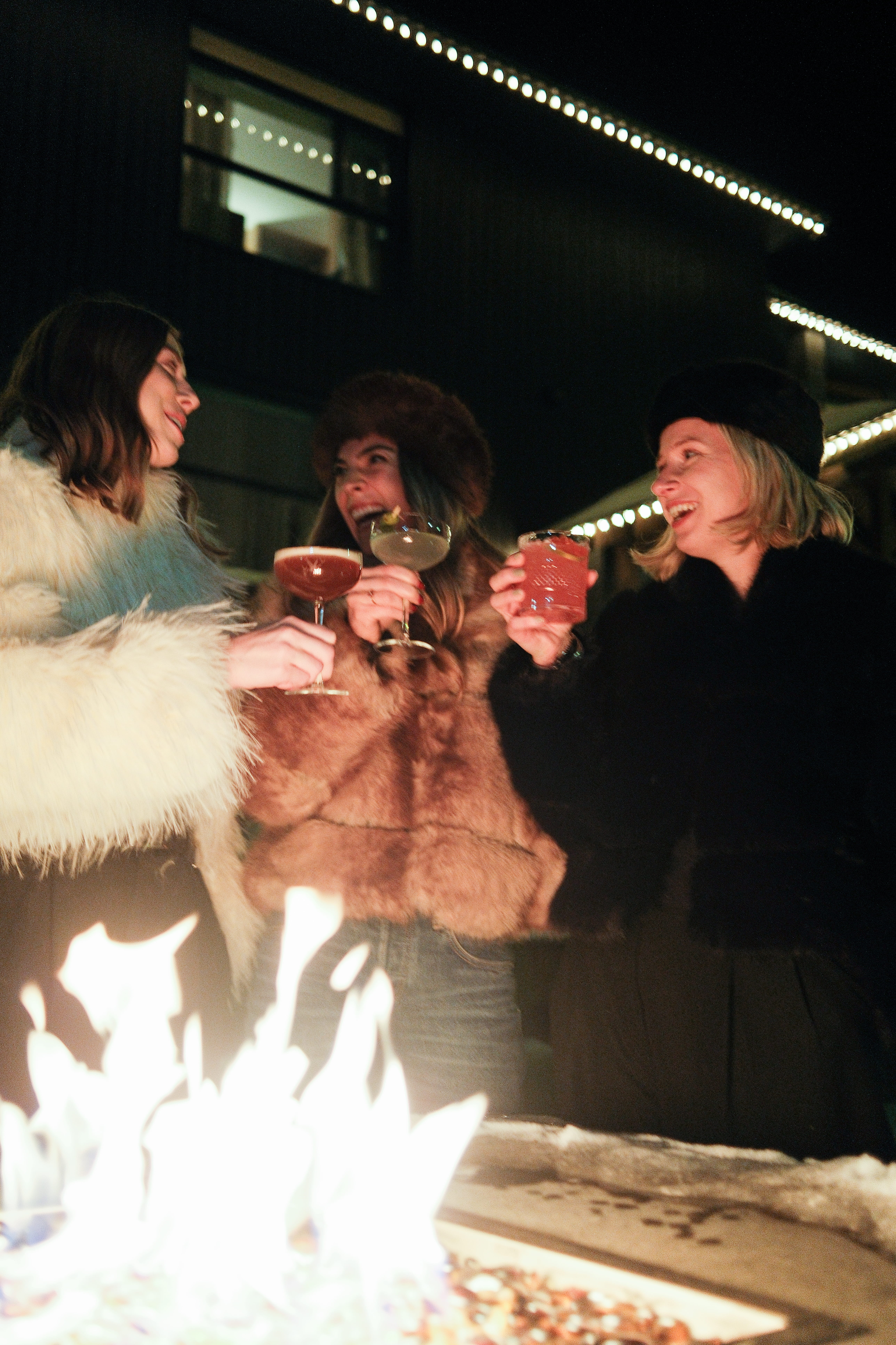 Christmas party guests enjoying cocktails by the fire at The Fat Ox in Banff
